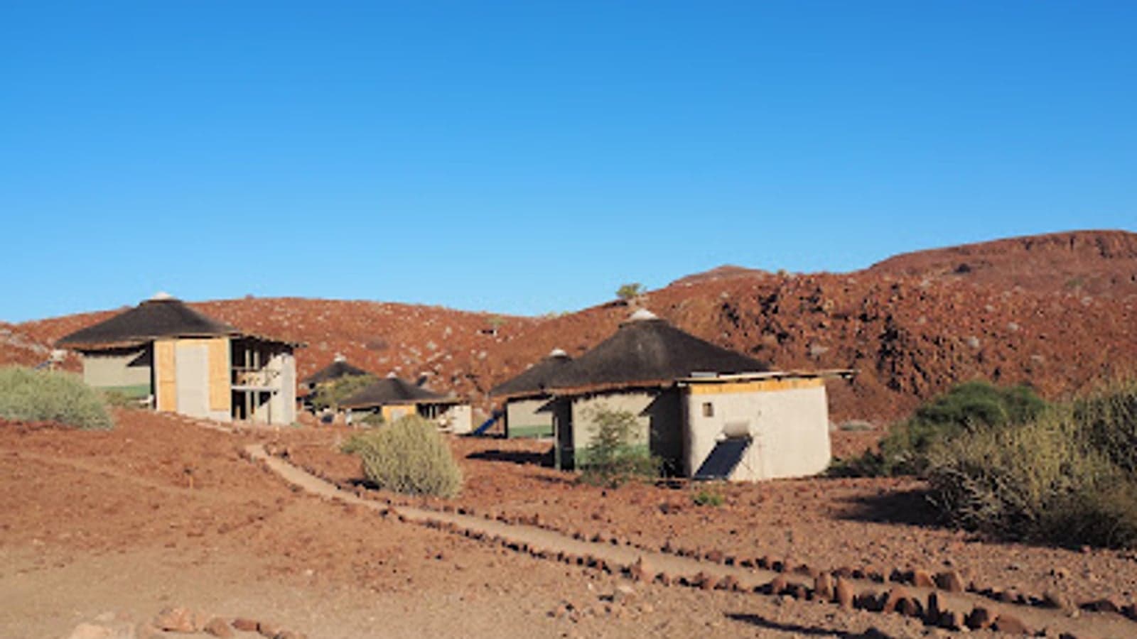 Thatched chalets set among red rock hills at Damaraland Camp