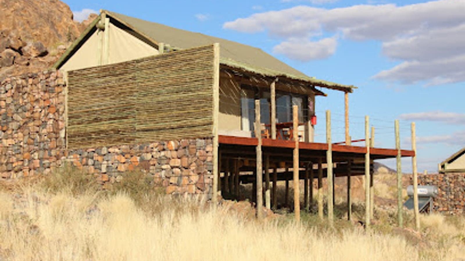 A canvas tent with private deck on a rocky outcrop at The Elegant Desert Camp, Sossusvlei